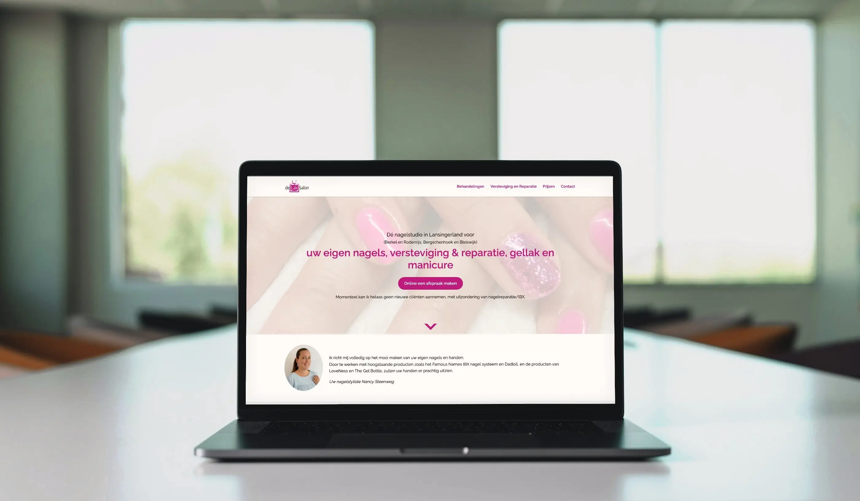 De website van De Lak Salon op het scherm van een laptop op een witte vergadertafel.