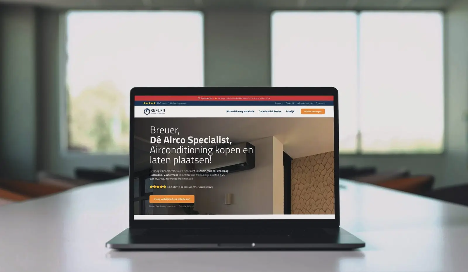Een laptop met de website van een klant op een tafel.