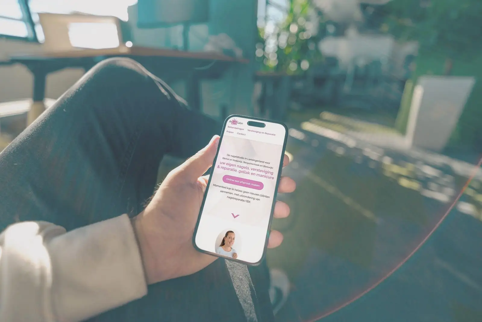 Een telefoon in een hand met de app van een klant op het scherm.